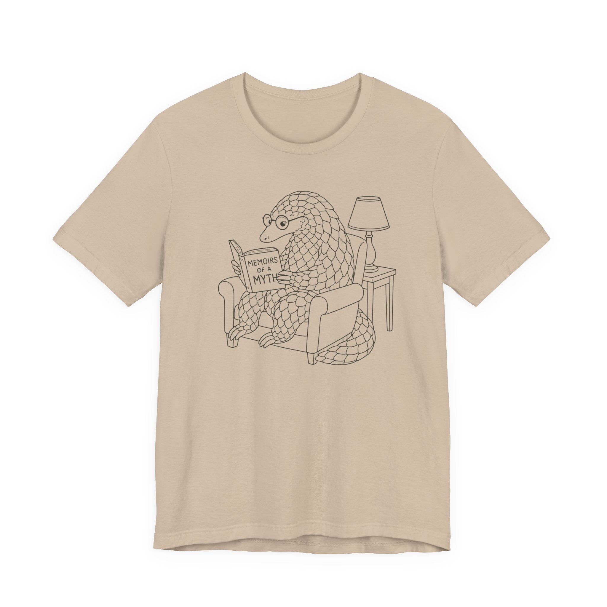 Beige t-shirt with a graphic of a pangolin reading a book titled &#39;Memoirs of a myth&#39; on a white background.