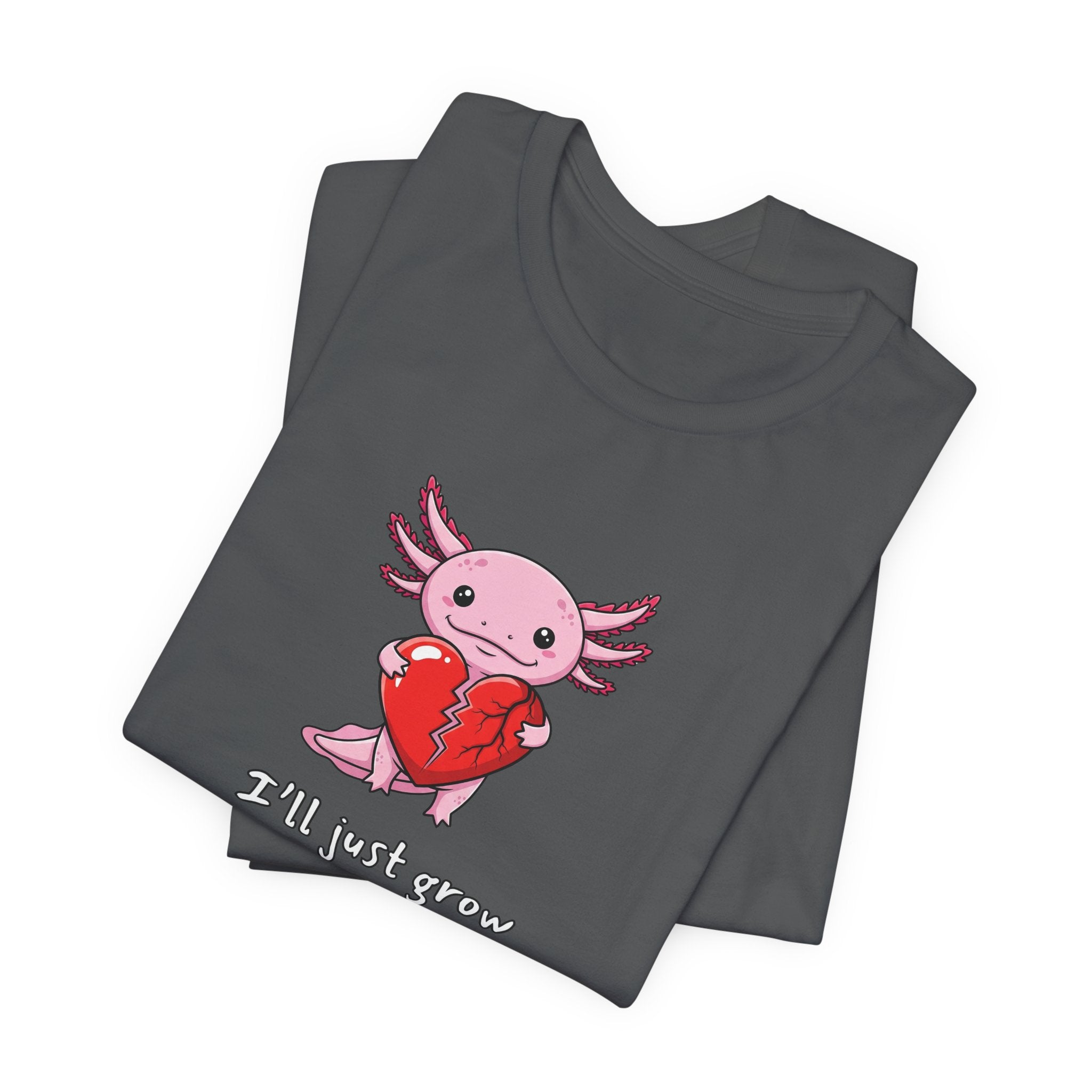 Folded gray t-shirt with axolotl graphic with a broken heart and text "I'll just grow a new one" by Soon To Be Mythical