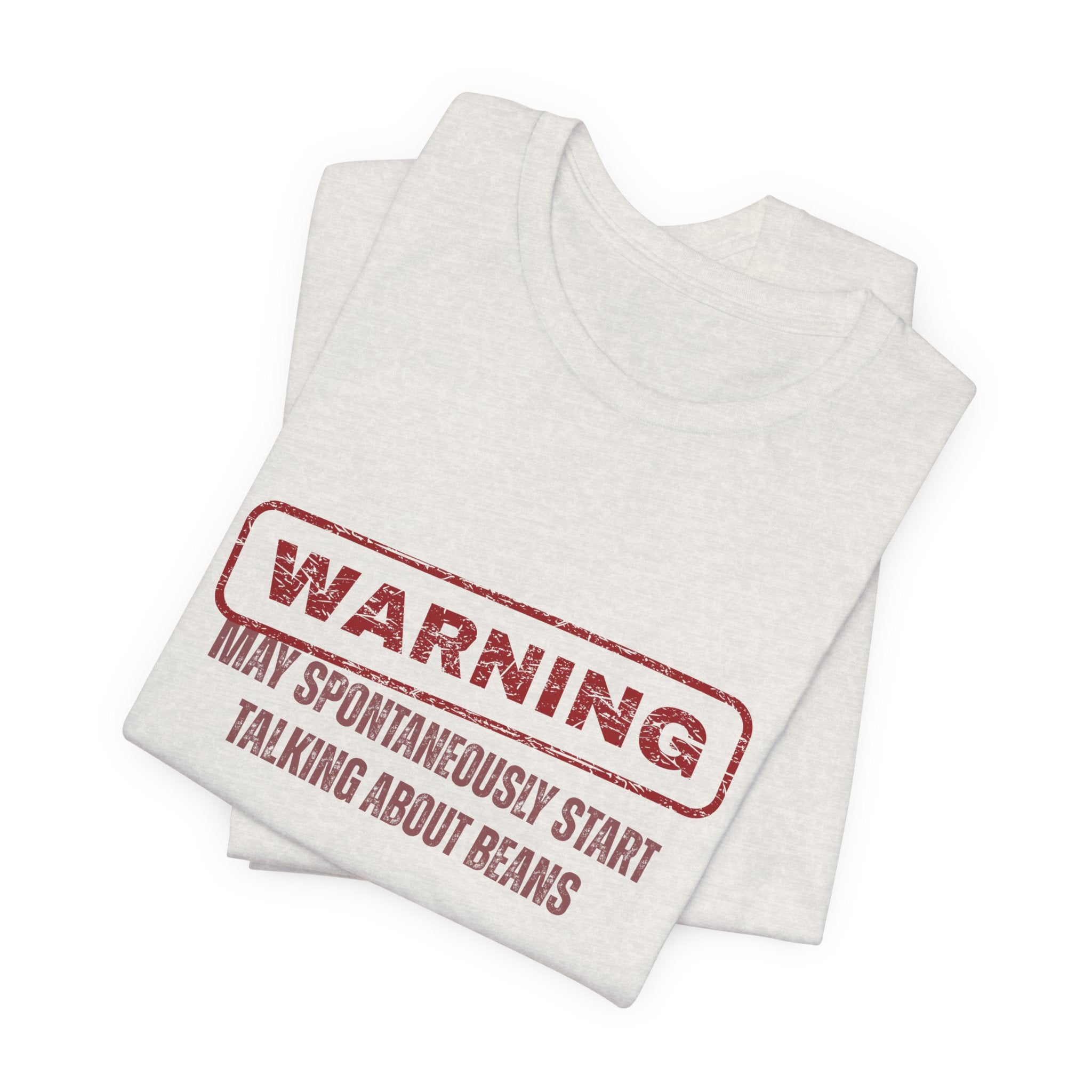 Folded white t-shirt with red text "Warning - may spontaneously start talking about beans" by Soon To Be Mythical