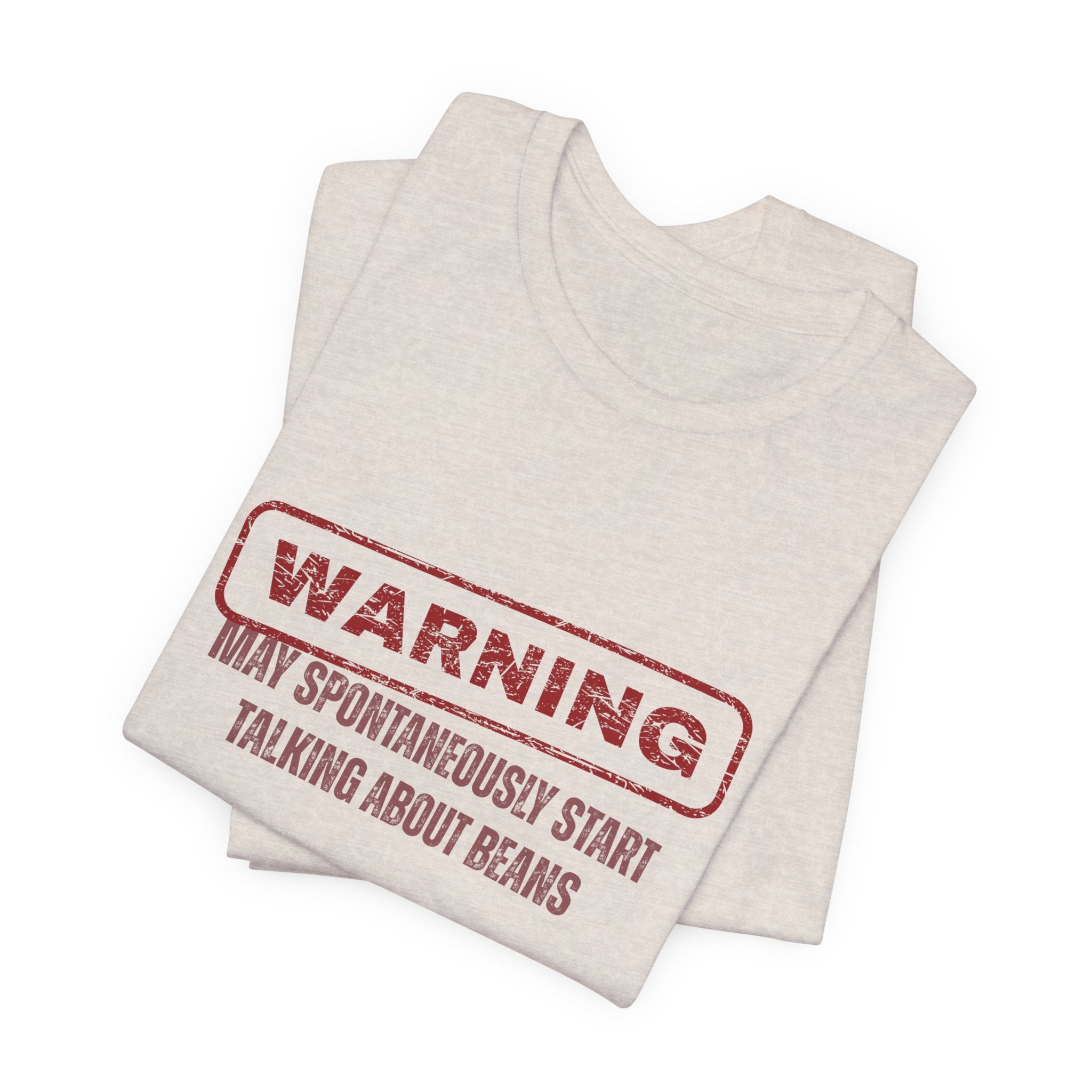 Folded beige  t-shirt with red text "Warning - may spontaneously start talking about beans" by Soon To Be Mythical