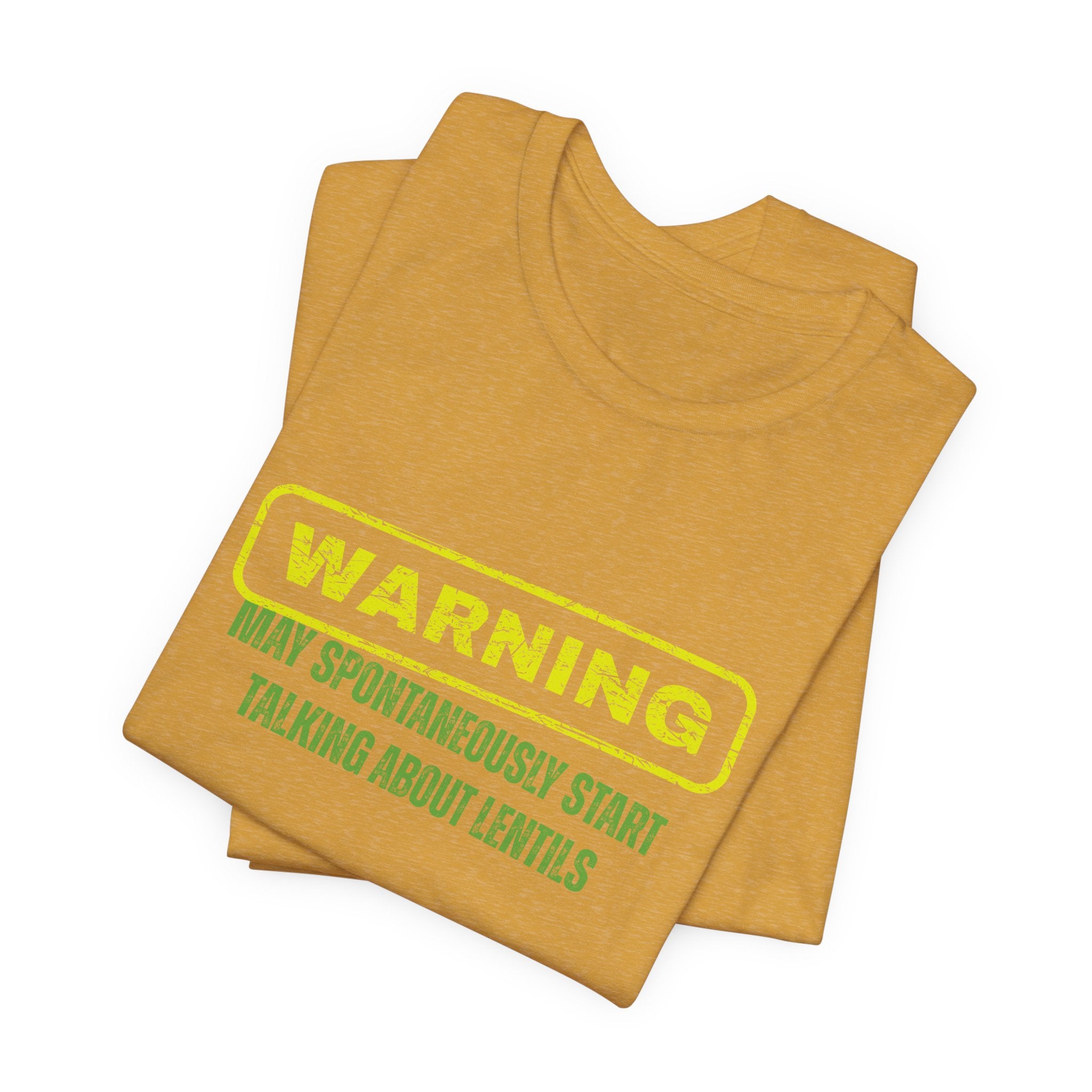Folded mustard yellow t-shirt with yellow and green text "Warning - may spontaneously start talking about lentils" by Soon To Be Mythical