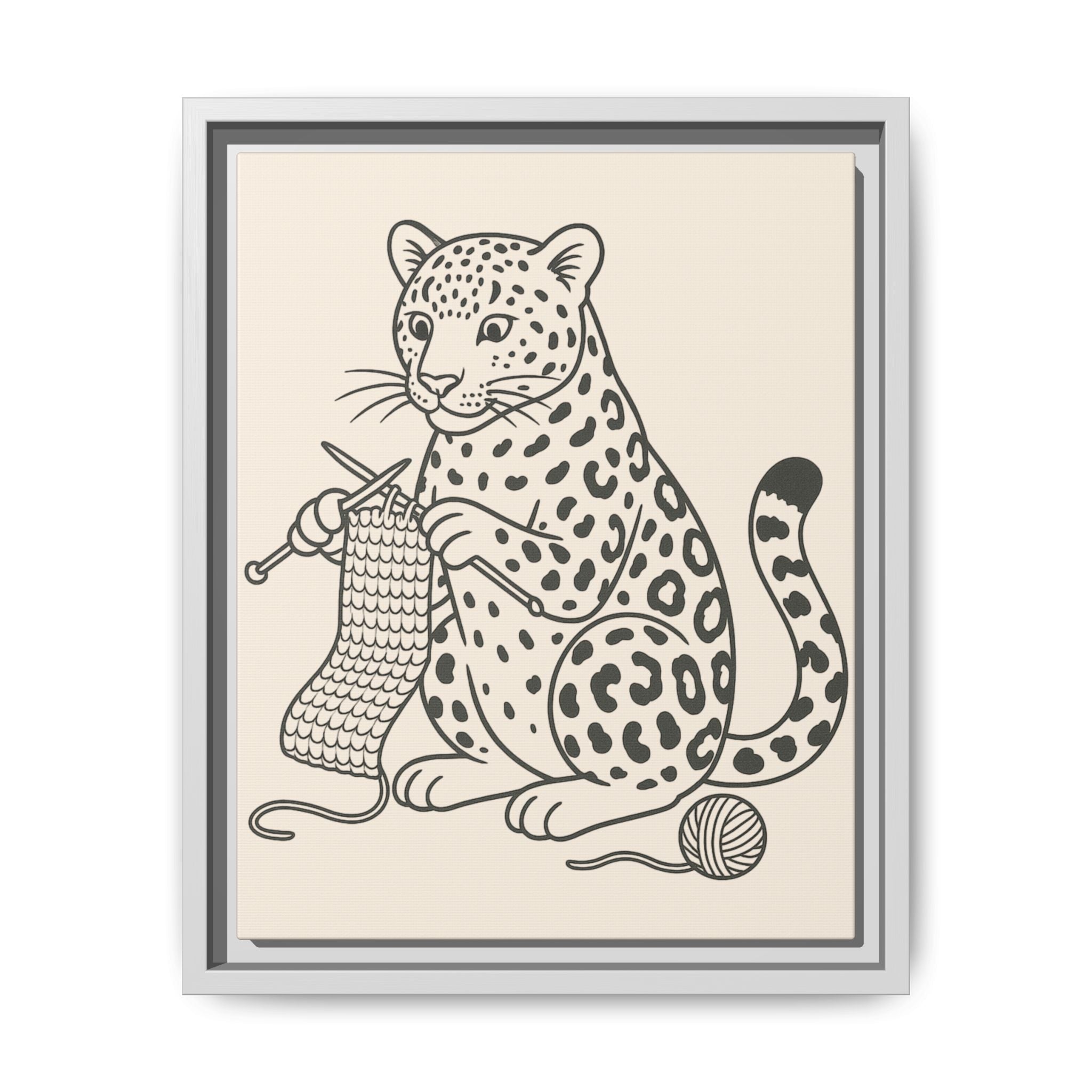 Framed artwork of an amur leopard with knitting needles and yarn on a beige background