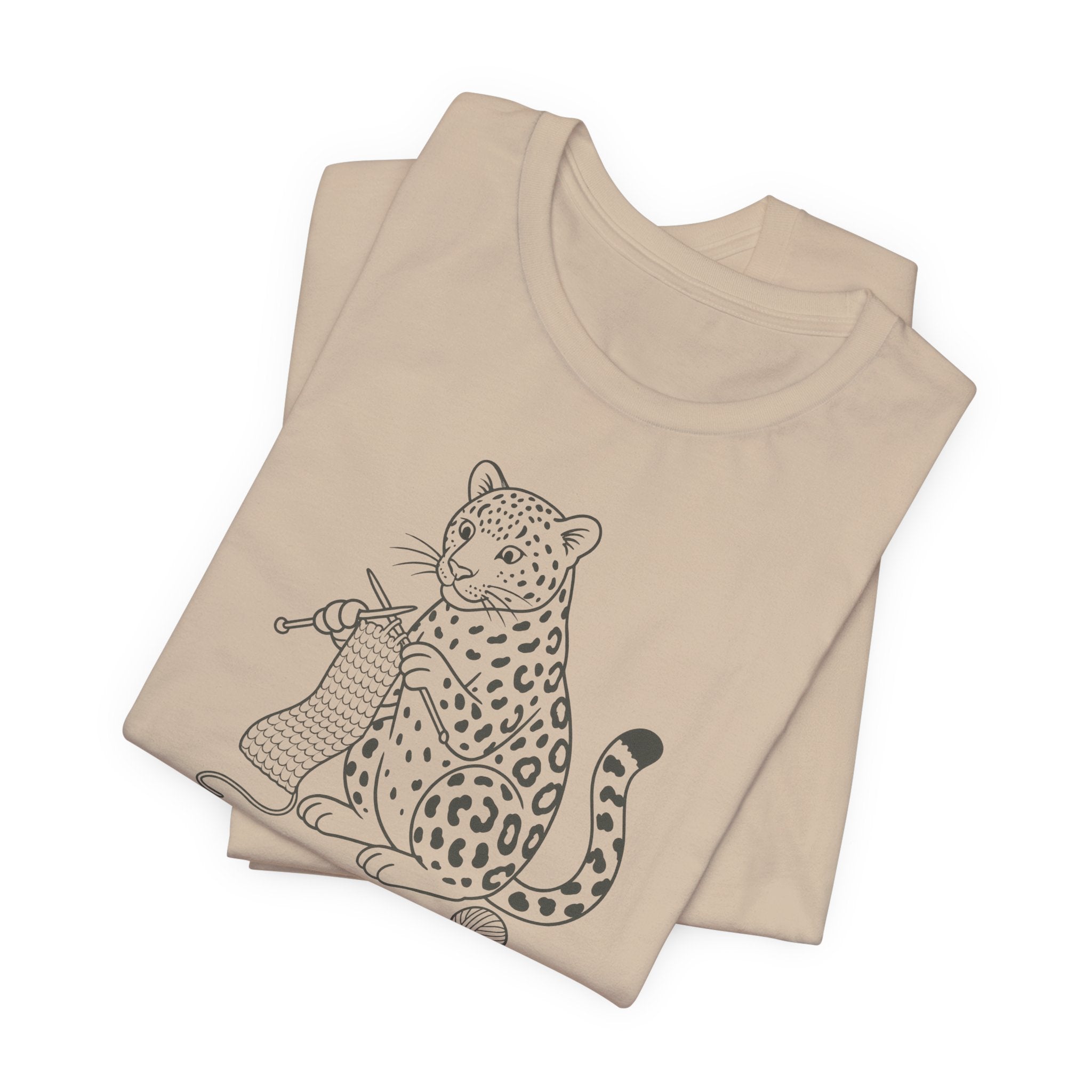 Tan t-shirt with a leopard design knitting a scarf on a white background