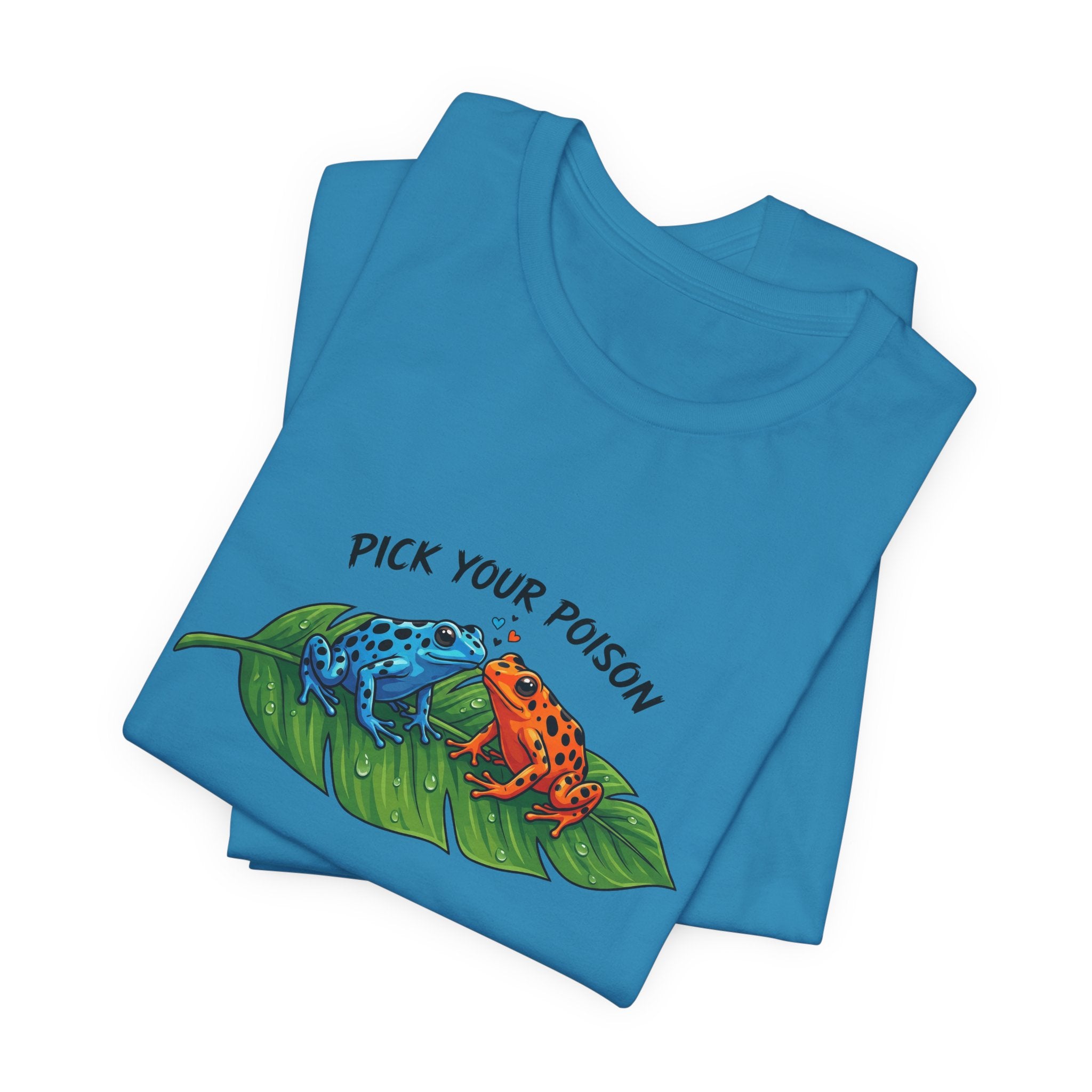 Folded blue t-shirt with a graphic of two poison dart frogs on a leaf and 'Pick Your Poison' text by Soon To Be Mythical