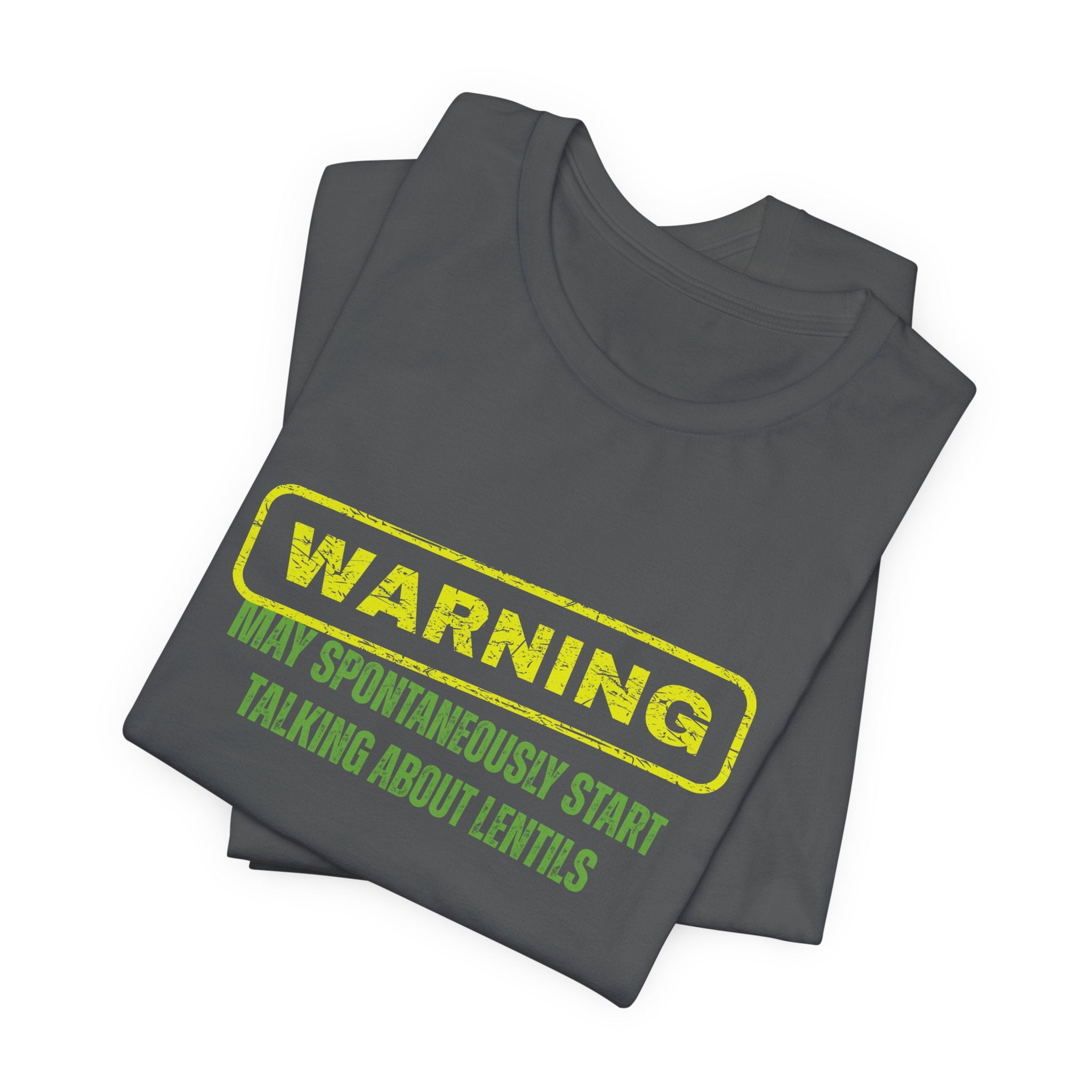 Folded gray t-shirt with yellow and green text "Warning - may spontaneously start talking about lentils" by Soon To Be Mythical