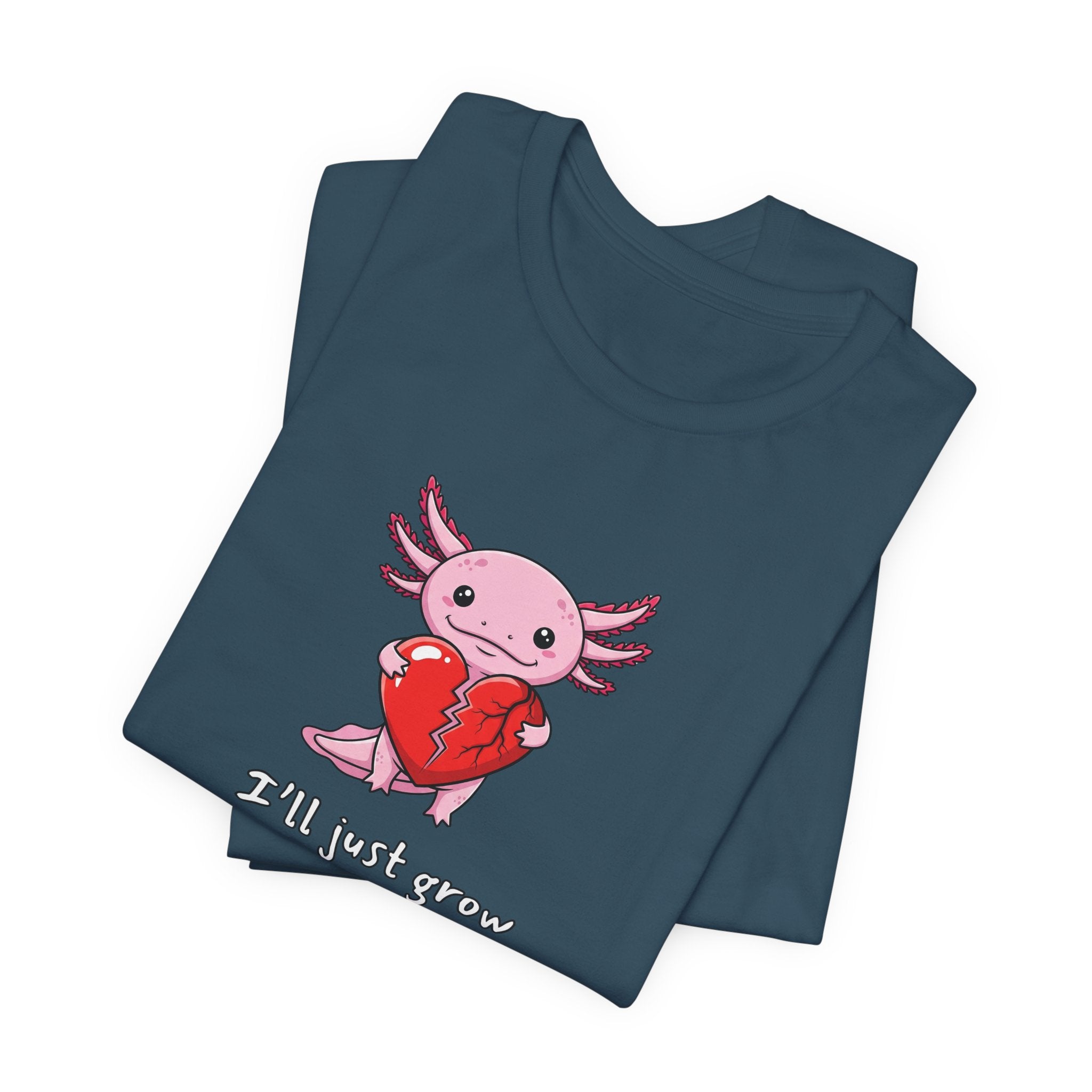 Folded deep teal t-shirt with axolotl graphic with a broken heart and text "I'll just grow a new one" by Soon To Be Mythical
