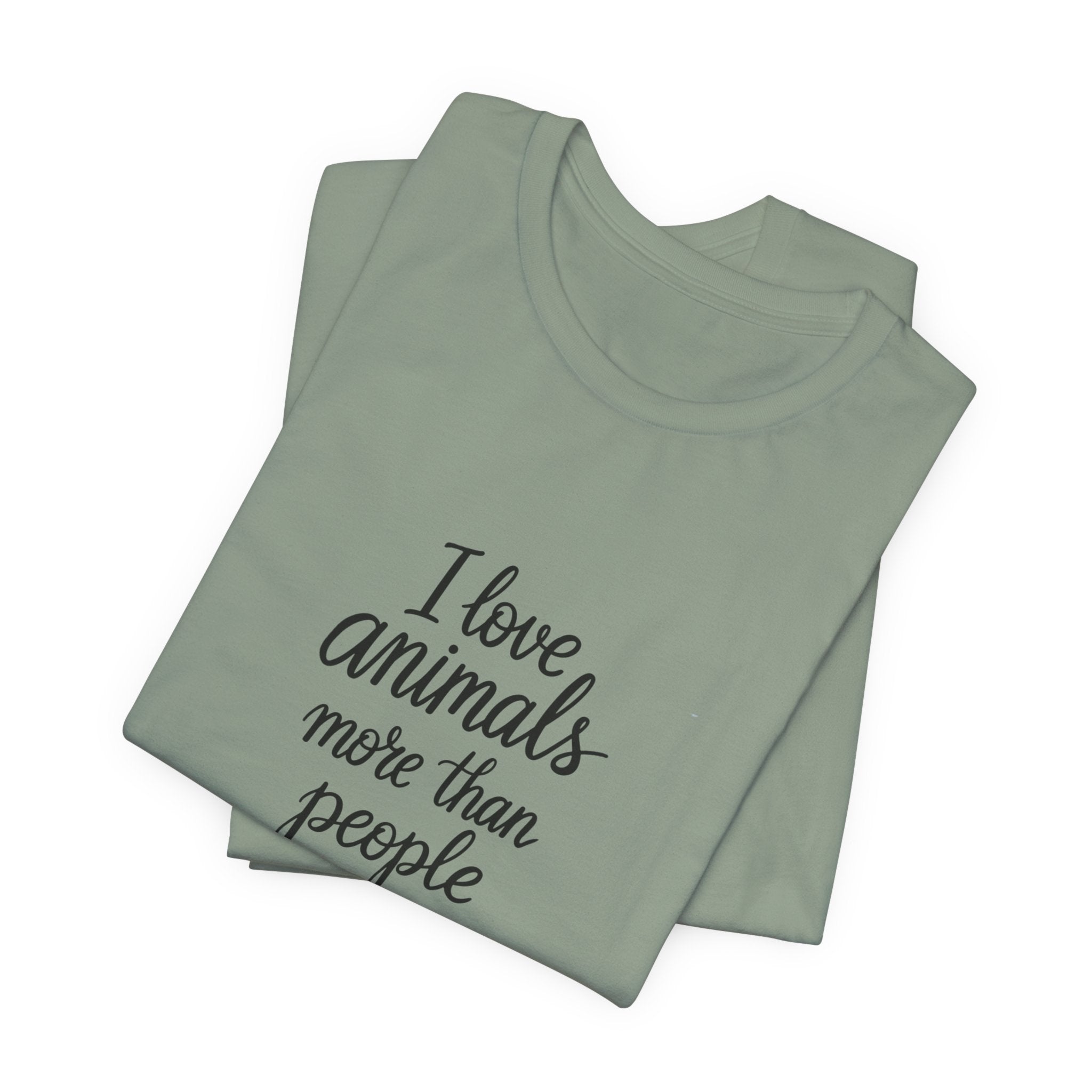 Sage green t-shirt with the text "I Love Animals More Than People" on the front and the text "Postpone the Myth" on the left sleeve on a white background