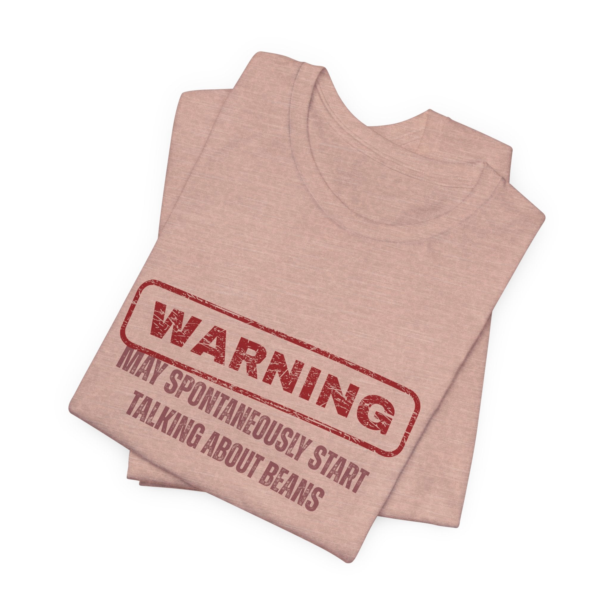 Folded pink  t-shirt with red text "Warning - may spontaneously start talking about beans" by Soon To Be Mythical