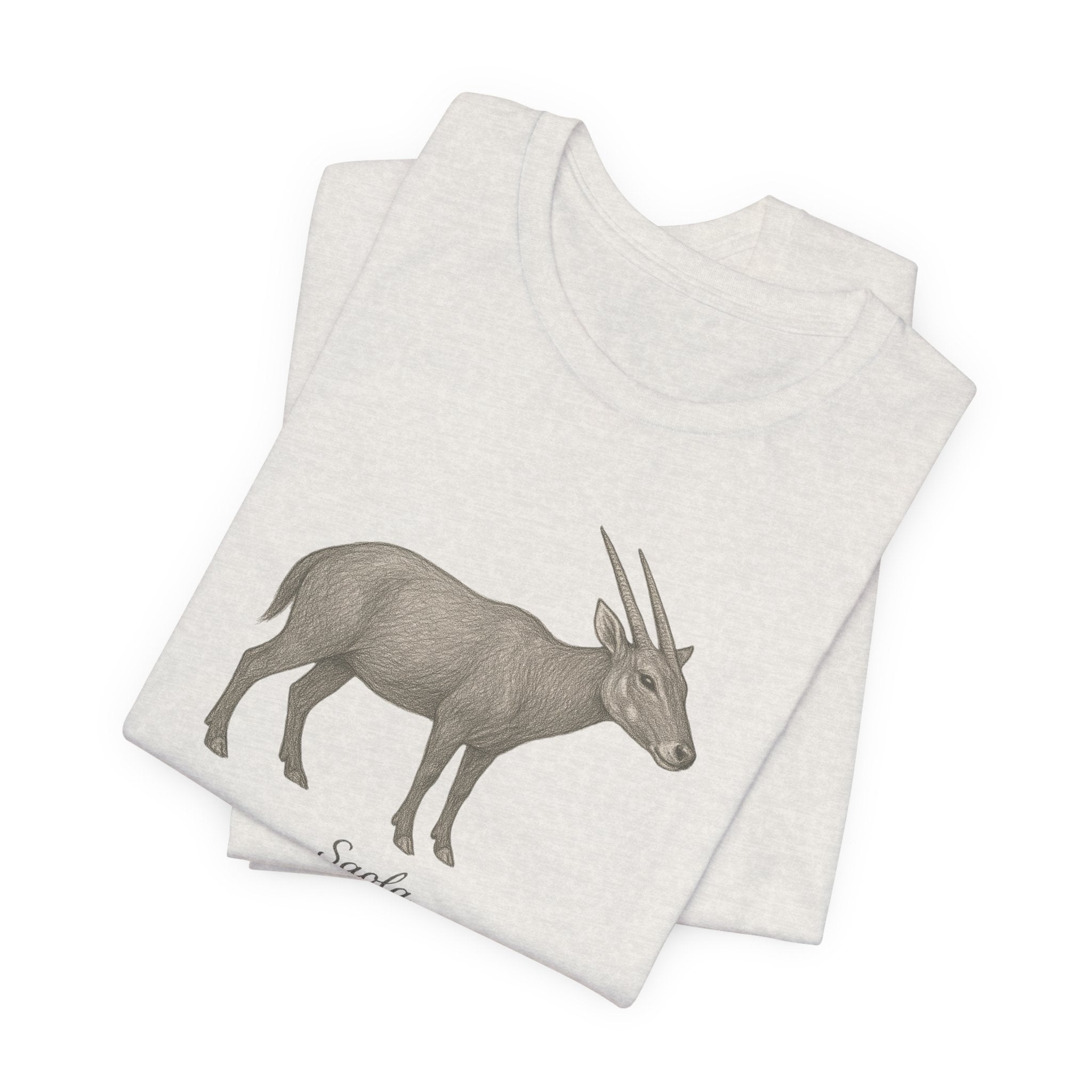 Folded heathered cement t-shirt with a saola illustration on a white background