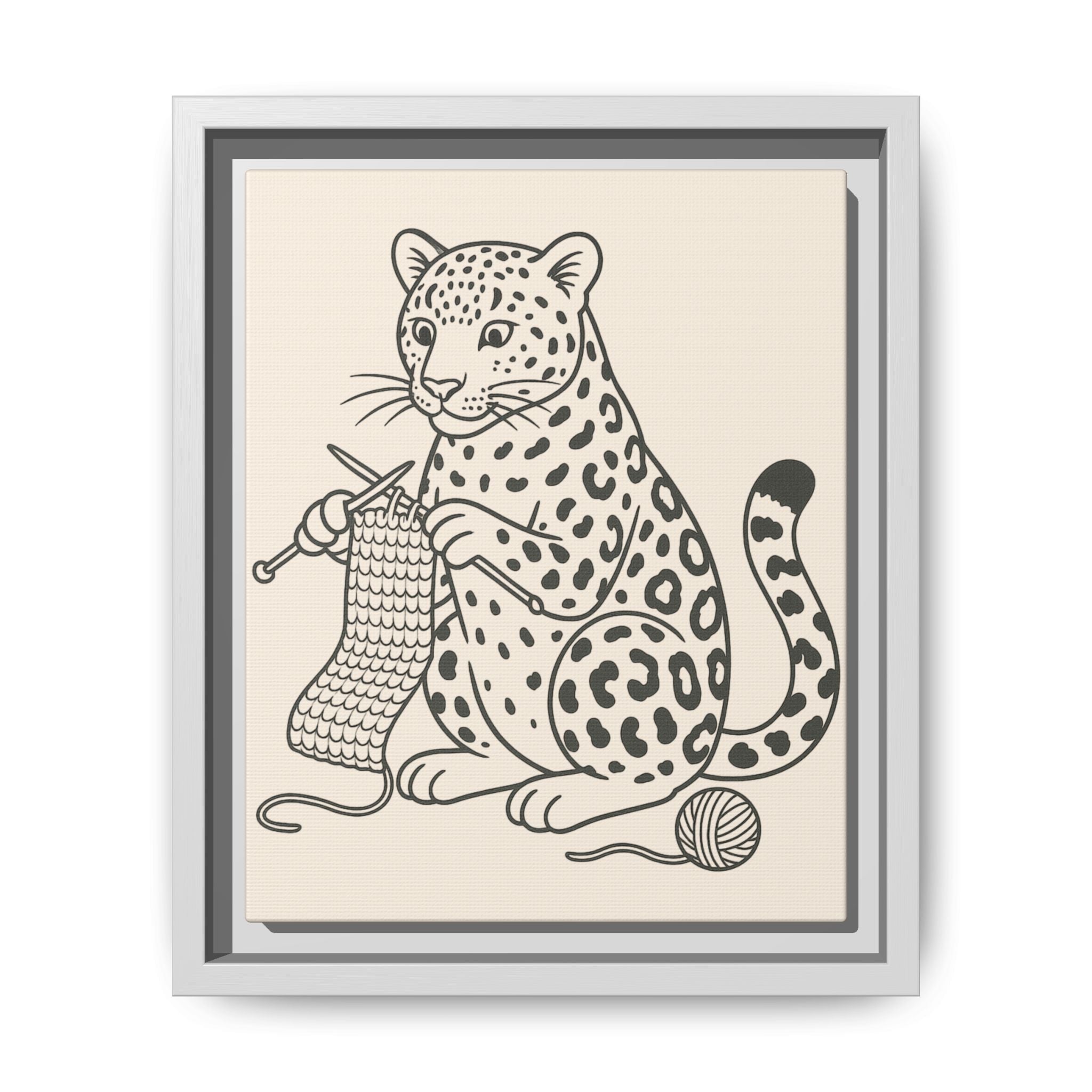 Framed artwork of an amur leopard with knitting needles and yarn on a beige background